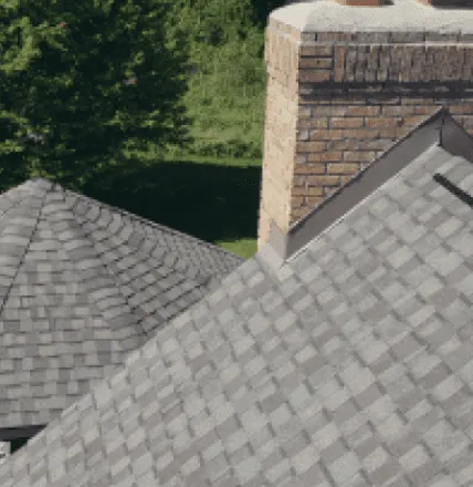 Gray asphalt shingle roof with brick chimney aerial view residential home