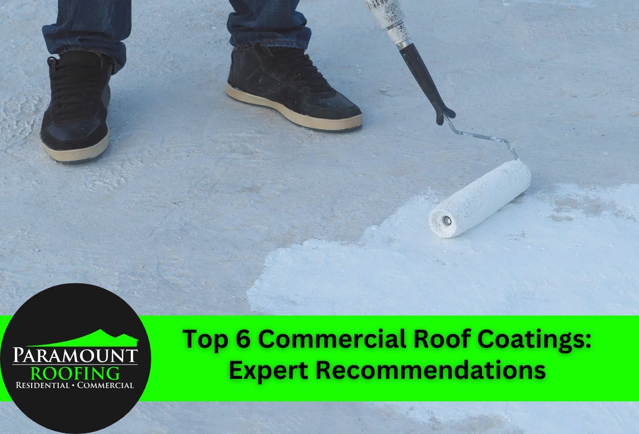 Worker applying commercial roof coating with paint roller on flat roof surface