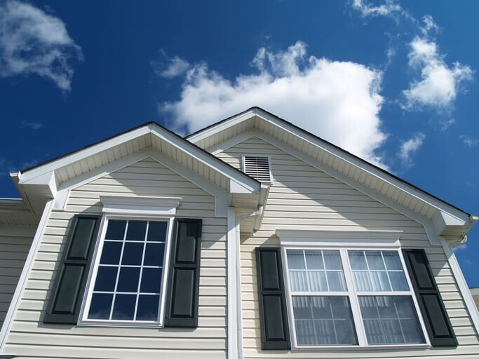 Close-up of a modern house facade under a clear blue sky.