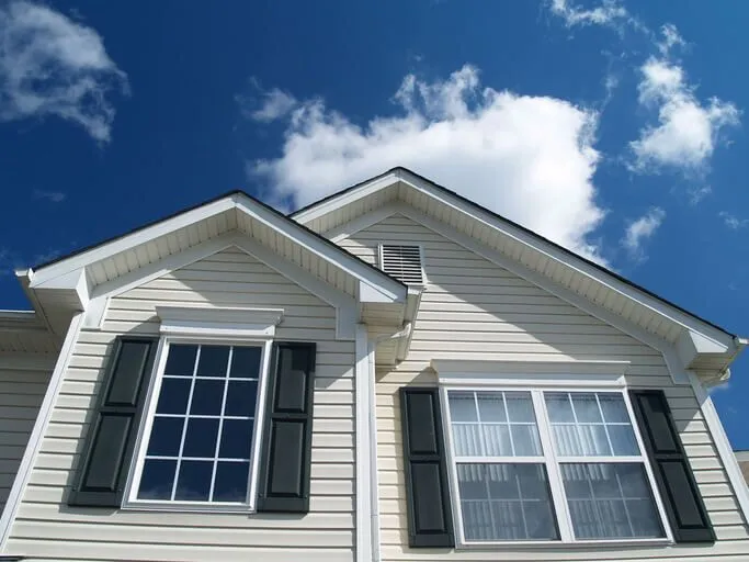 Close-up of a modern house facade under a clear blue sky.