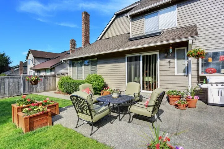 Cozy backyard patio with furniture and potted plants.