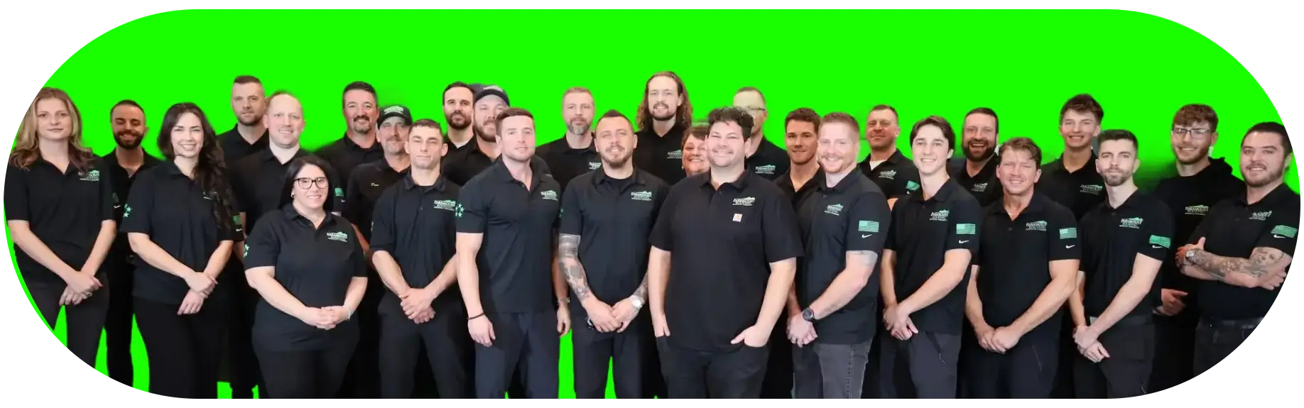 Group photo of employees in black uniforms on green background