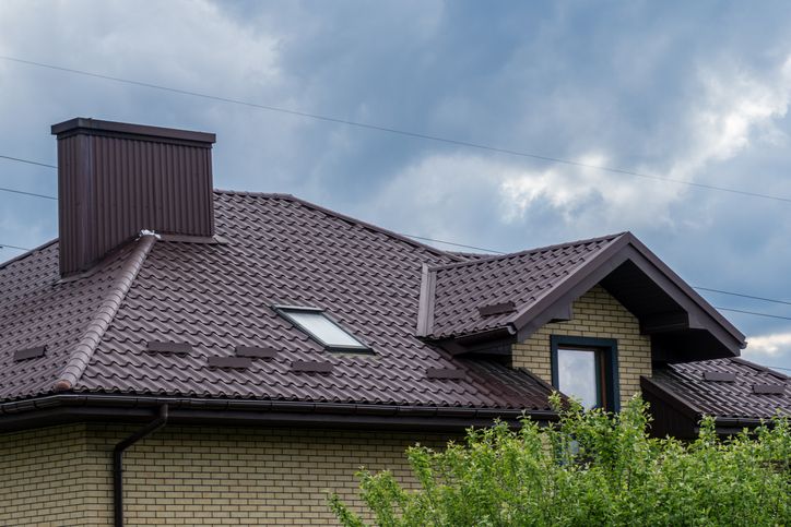 Modern house with metal roof against cloudy sky