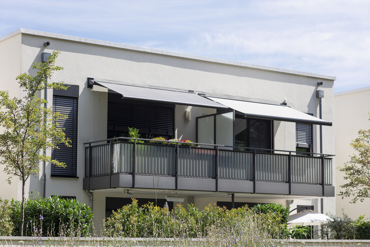 Modern house balcony with sliding doors and a sunshade